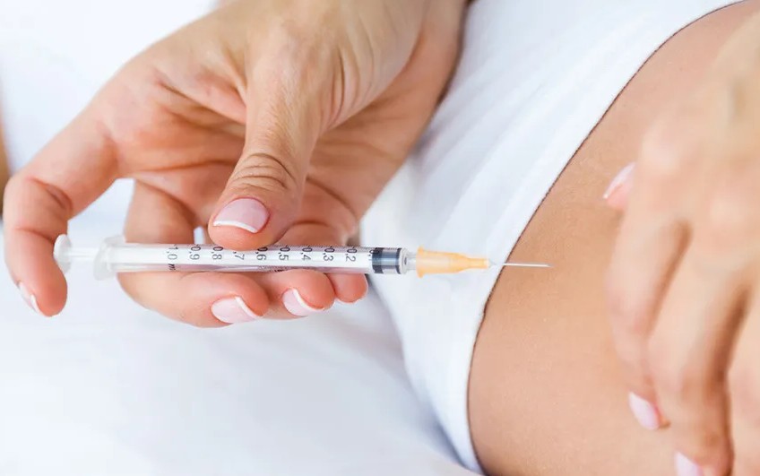 Clinician administering fat-dissolving injections to a patient's inner thigh area